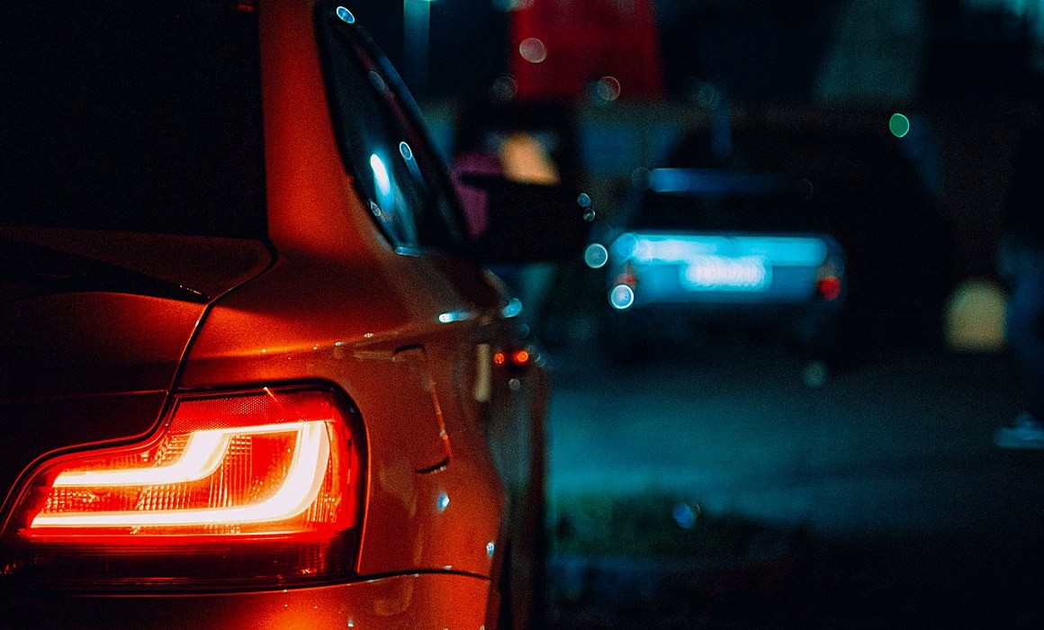 Lanterna traseira de um carro acesa à noite